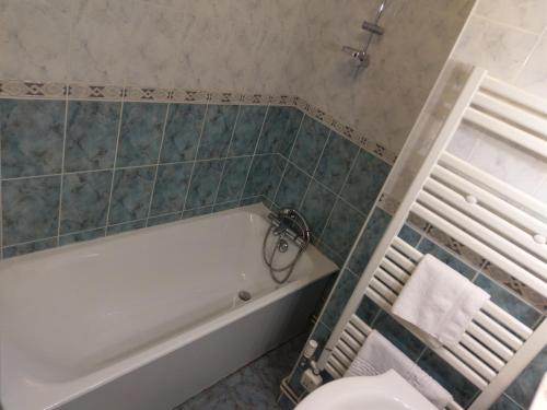 a bathroom with a tub and a toilet at Logis de L'Europe Restaurant Le Cepage in Corbigny