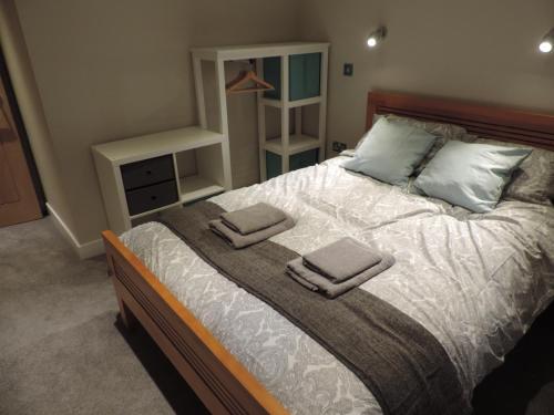 a bedroom with a bed with two towels on it at 4 Bed Farnborough Air Accommodation in Farnborough