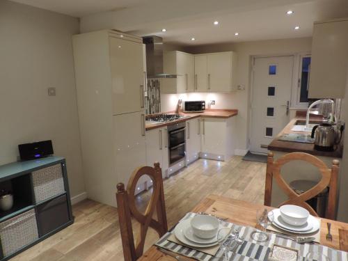 a kitchen and dining room with a table and chairs at 4 Bed Farnborough Air Accommodation in Farnborough
