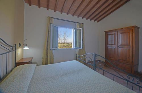 a bedroom with a bed and a window at Agriturismo L'Imposto in Pomarance