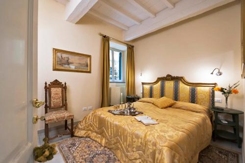 een slaapkamer met een groot bed en een stoel bij Via dei Fossi apartment in Florence