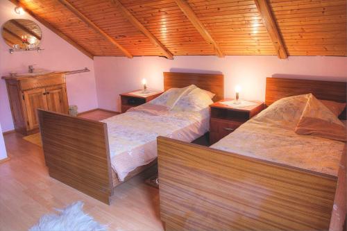 2 Betten in einem Zimmer mit 2 Lampen an Tischen in der Unterkunft Apartman Maryla in Ratkovica