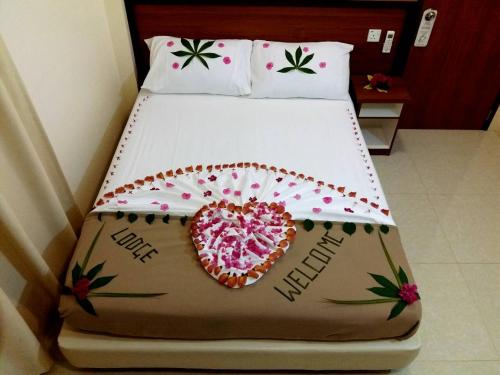 a bedroom with a bed with a heart on it at Hulhan'gu Lodge in Himmafushi