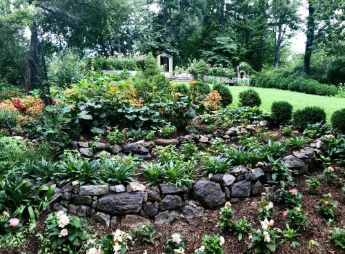 a garden with a stone wall and flowers at Gramercy Mansion in Stevenson