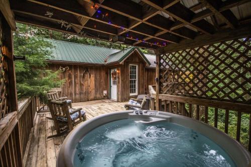 une baignoire sur le pont d'une cabine dans l'établissement Autumn Ridge- Cozy cabin in the Blue Ridge Mountains with a bubbly hot tub!, à Big Meadows