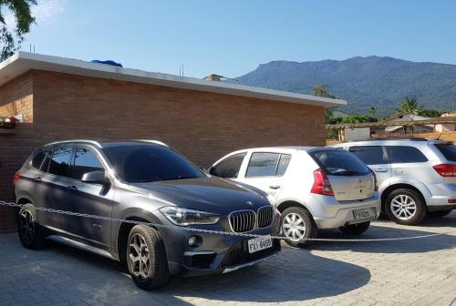 un grupo de tres coches estacionados en un estacionamiento en Chales Ilhabela ll, en Ilhabela