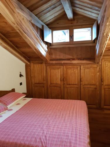 a bedroom with a bed in a room with wooden cabinets at Il rifugio delle marmotte in Pré-Saint-Didier