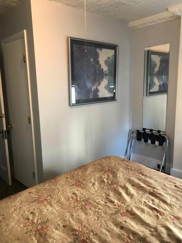 a bedroom with a bed and a picture on the wall at Maple Hill Farm Bed & Breakfast in New London