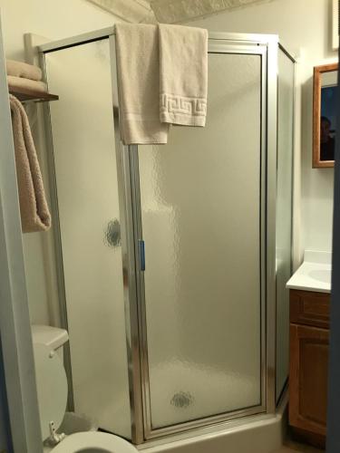 a shower with a glass door in a bathroom at Maple Hill Farm Bed & Breakfast in New London