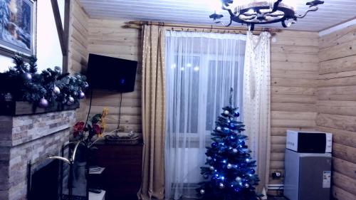 a blue christmas tree in a room with a fireplace at Karpatska Mria in Yaremche