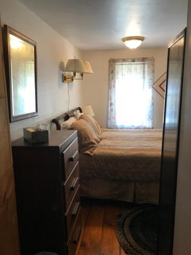 a small bedroom with a bed and a window at Maple Hill Farm Bed & Breakfast in New London