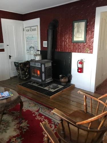 a living room with a woodburning stove in a room at Maple Hill Farm Bed & Breakfast in New London
