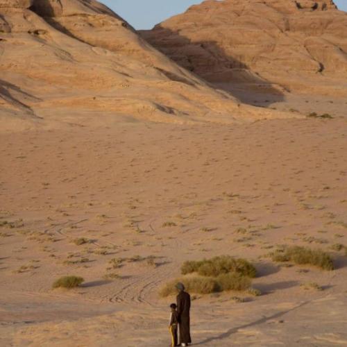a man and a child standing in the desert at Climbers House in Wadi Rum in Wadi Rum