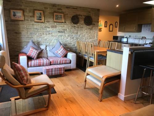 a living room with a couch and a table at Ty Nant Cottages and Suites in Carterton