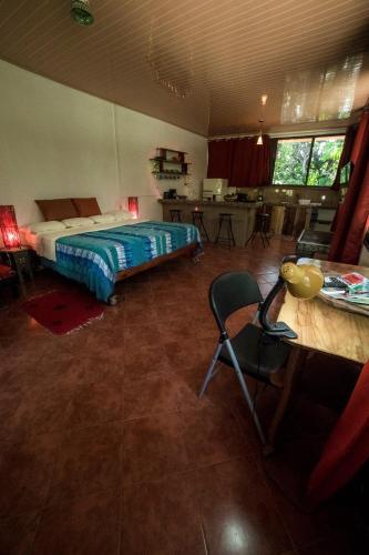 a bedroom with a bed and a chair in a room at Blanconejo de Montezuma in Montezuma