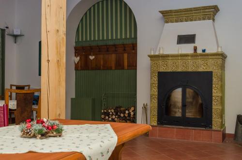 a room with a fireplace and a table with flowers on it at Penzion SPORTINO in Svoboda nad Úpou