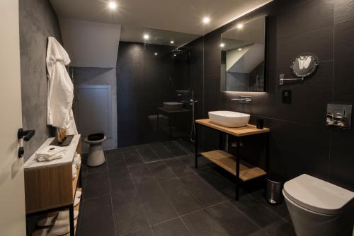a black bathroom with a sink and a toilet at Cugo Gran Macina Malta in Senglea