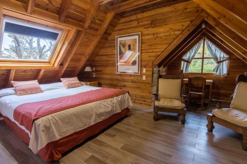1 dormitorio con 1 cama en una cabaña de madera en Cabañas Las Marias Del Nahuel en San Carlos de Bariloche