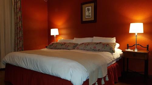 a bedroom with a large bed with two lamps at Estancia Turística San Pedro de Timote in Reboledo