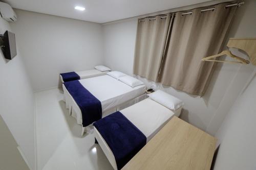 a small room with two beds and a window at Ecotel in Ribeirão Preto