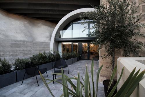 a courtyard with chairs and plants in a building at Cugo Gran Macina Malta in Senglea