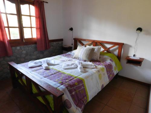 ein Schlafzimmer mit einem Bett mit Handtüchern darauf in der Unterkunft Cabañas Aldea de Montaña in Lago Puelo