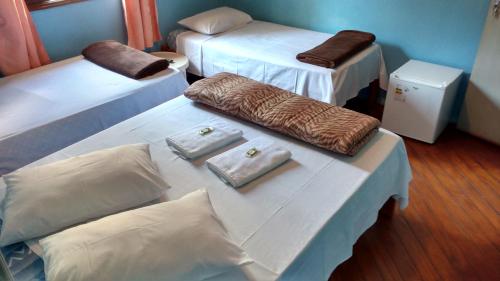 Habitación con 2 camas y toallas en una mesa. en Hotel Paulista, en São Vicente