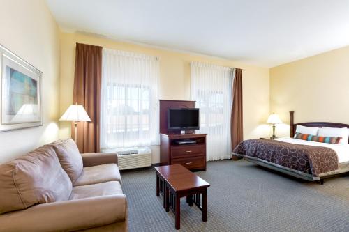 a hotel room with a bed and a couch at Staybridge Suites McAllen by IHG in McAllen
