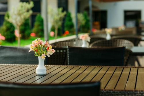 a white vase with flowers sitting on a table at Hotel Intourist Palace Batumi in Batumi