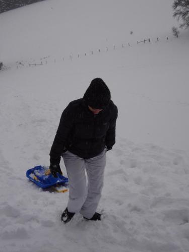 a man standing in the snow with a snowboard at An Hütten in Herresbach