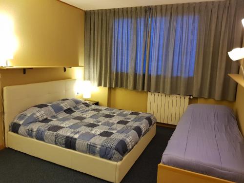 una camera d'albergo con letto e finestra di Appartamento Foemina ad Abetone