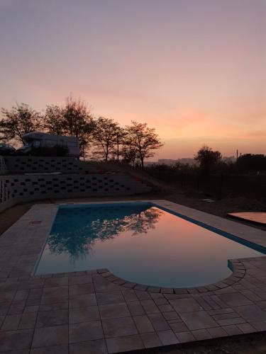 una piscina con puesta de sol en el fondo en Agriturismo bio Verde Armonia, en Montemarciano