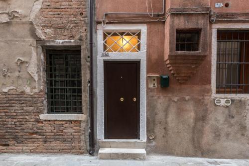 a building with a black door and two windows at La Loggia della Luna in Venice