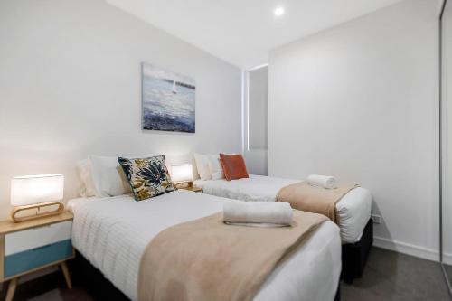 a hotel room with two beds and two lamps at Astra Apartments Newcastle Beach in Newcastle