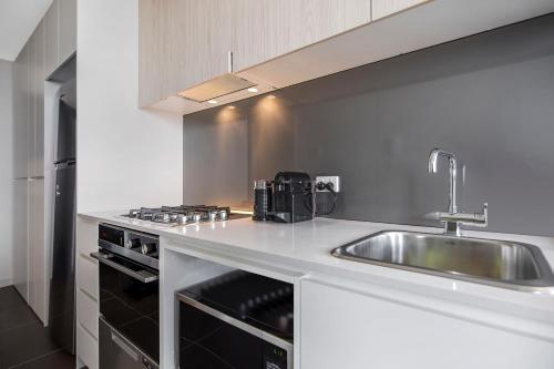 a kitchen with a sink and a counter top at Astra Apartments Newcastle Beach in Newcastle