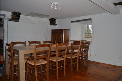 a dining room with a table and wooden chairs at Gitesonoro Beho in Gouvy