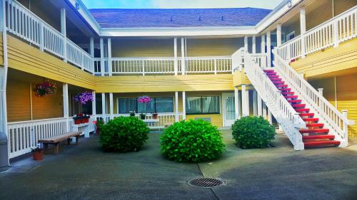 a yellow building with a staircase on the side of it at GuestHouse Inn Enumclaw in Enumclaw