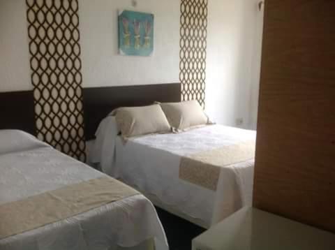 a hotel room with two beds and a window at Complejo Turistico Anaconda Hotel in La Paloma