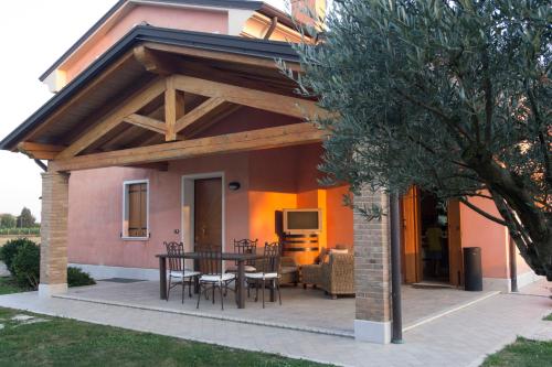 a patio with a table and chairs in front of a house at VillaRosa in Santa Lucia di Piave