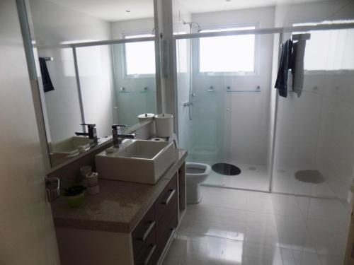 ein Badezimmer mit Waschbecken, Dusche und Toilette in der Unterkunft Temporada Praia de Palmas SC in Governador Celso Ramos