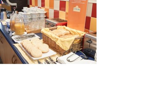 a counter with baskets of bread and bottles of orange juice at Ventura Inn & Suites Hamilton in Hamilton
