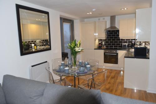a living room with a table and a kitchen at Matysiak Apartment in Edinburgh