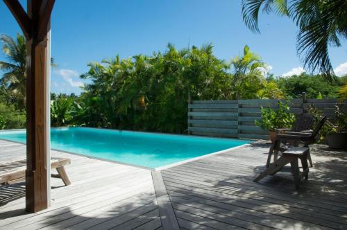 une terrasse avec une piscine, une table et des chaises dans l'établissement Villa Tiarés, à Saint-François