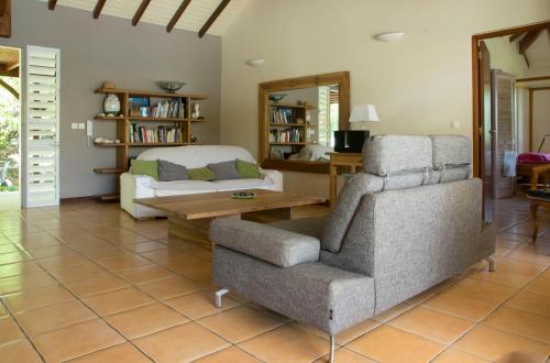 - un salon avec une chaise et un canapé dans l'établissement Villa Tiarés, à Saint-François