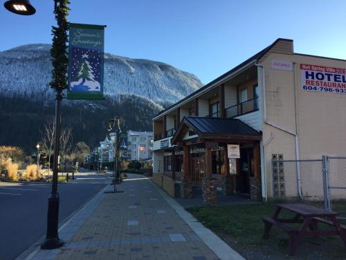 a street with a hotel with a mountain in the background at Spring Villa Hotel in Harrison Hot Springs