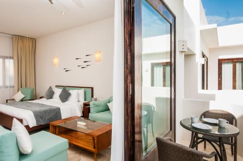 a bedroom with a bed and a living room at Mak Nuk Village - Clothing Optional in Tulum
