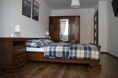 a bedroom with two beds and a dresser at Apartament Izerski Klimat in Świeradów-Zdrój