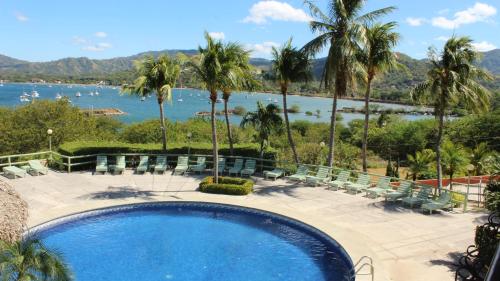 a swimming pool with chairs and a view of the water at Flamingo Marina Hotel in Playa Flamingo