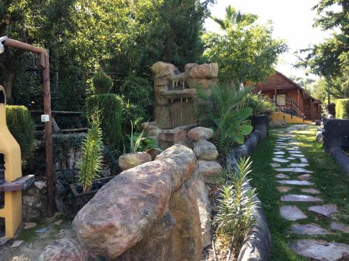 a garden with a fence and a large rock at Cabañas De Madera Y Bungalows - Gilmañas 3 in La Iruela