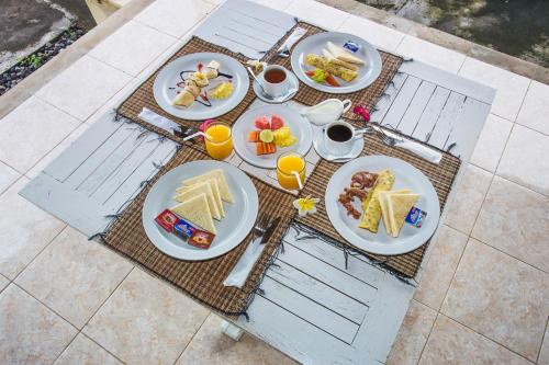 un tavolo con sopra piatti di cibo per la colazione di Bukit Taman Cottages a Nusa Lembongan
